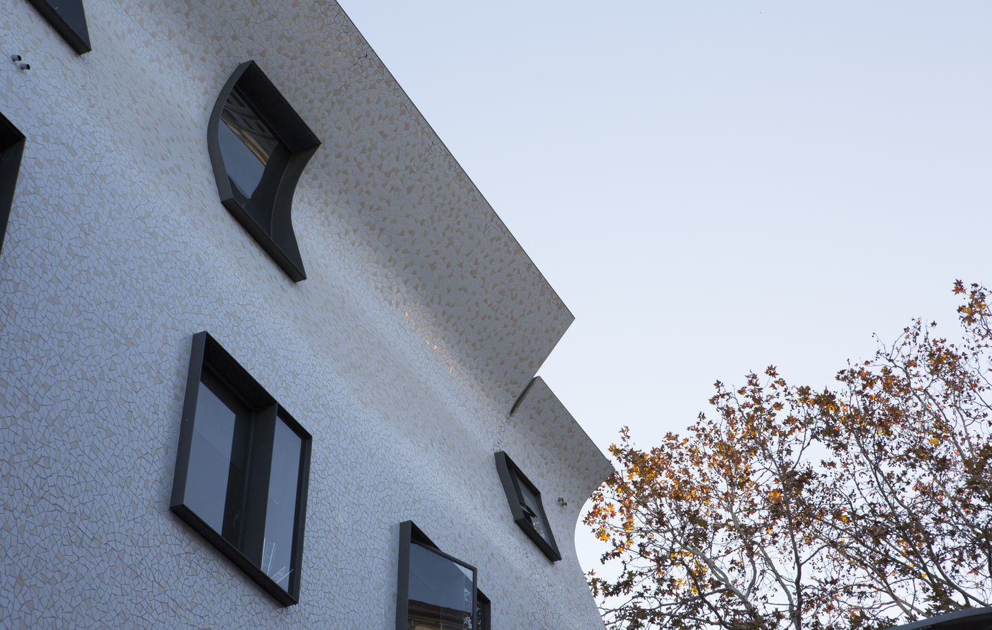Roslyn Street  Office building with curved tiled walls and dark grey steel windows in Roslyn Street Potts Point Sydney designed by Durbach Block Jaggers Architects