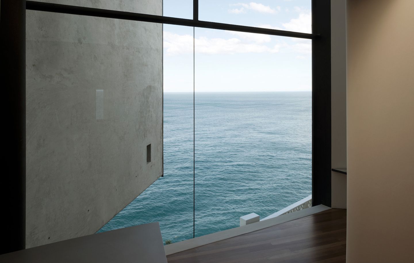 View of ocean and horizon through frameless glass at cliff front house at Dover Heights Sydney designed by Durbach Block Jaggers Architects