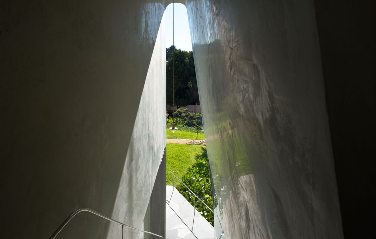 Polished plaster arch framing view of garden at family house in Dover Heights Sydney designed by Durbach Block Jaggers Architects