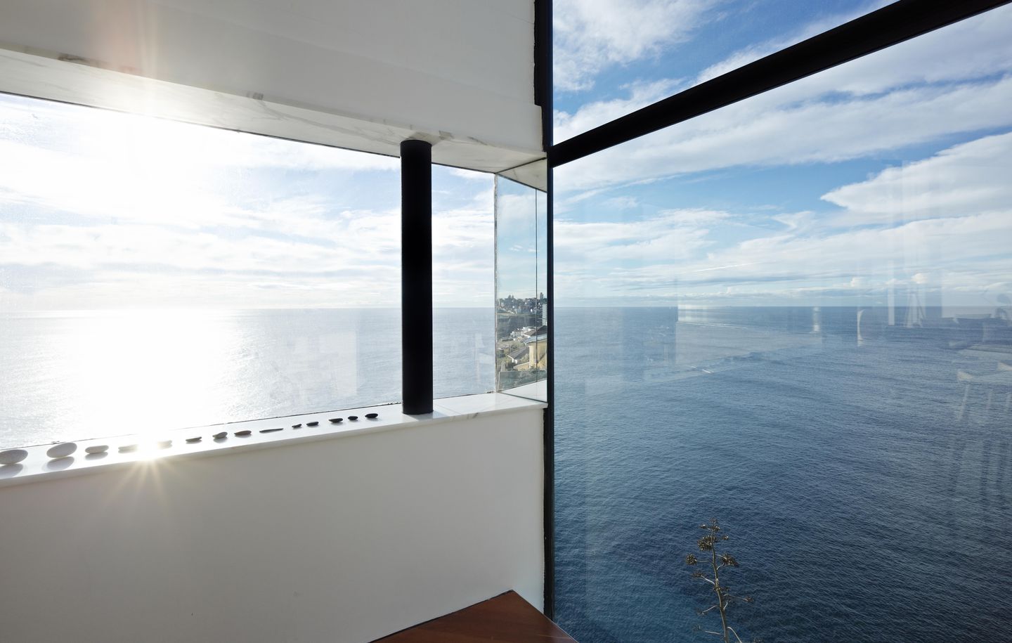 Dark grey steel and Carrara marble window looking out over cliff in house at Dover Heights Sydney designed by Durbach Block Jaggers Architects